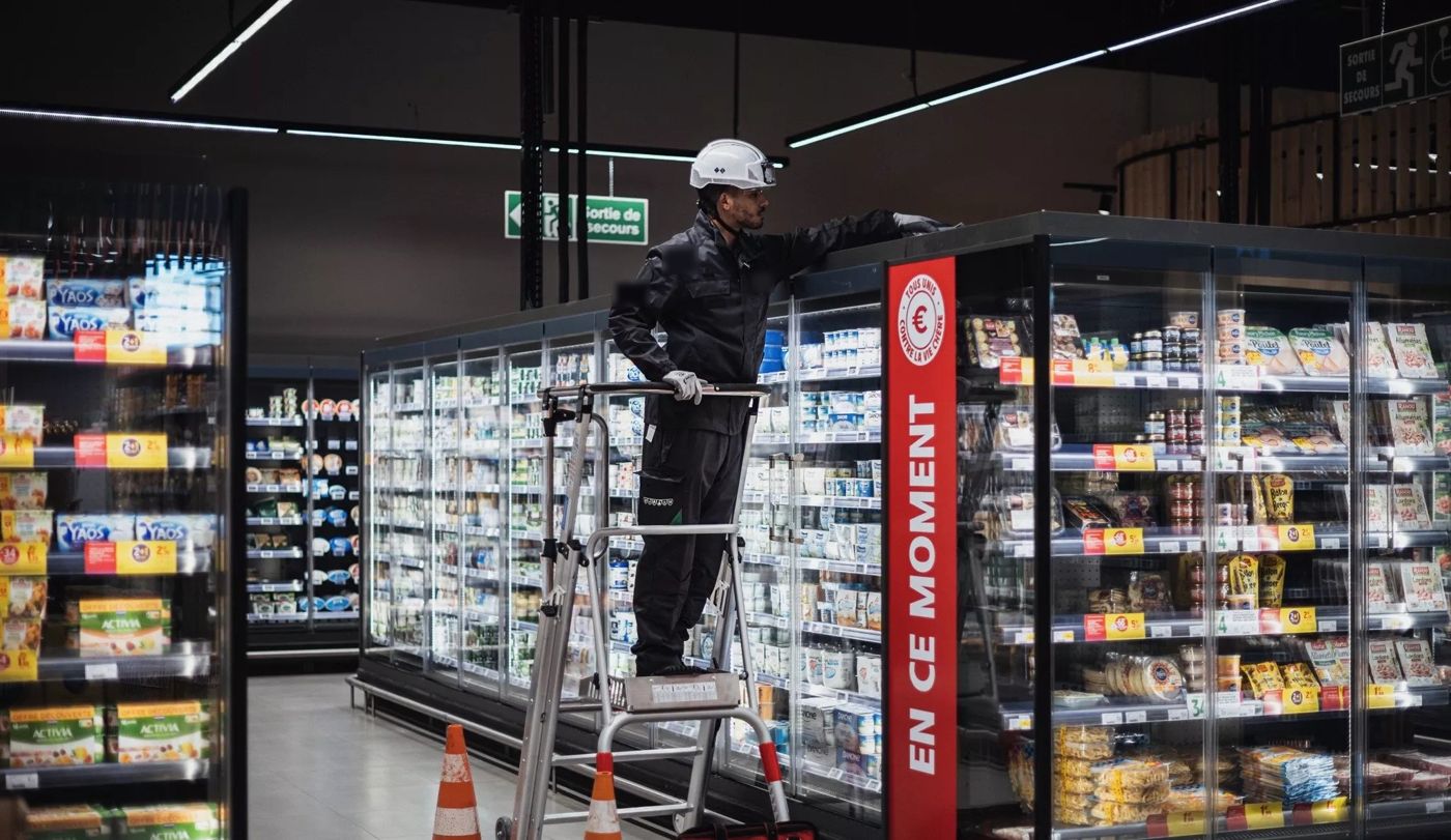 Technicien en intervention dans une allée de supermarché